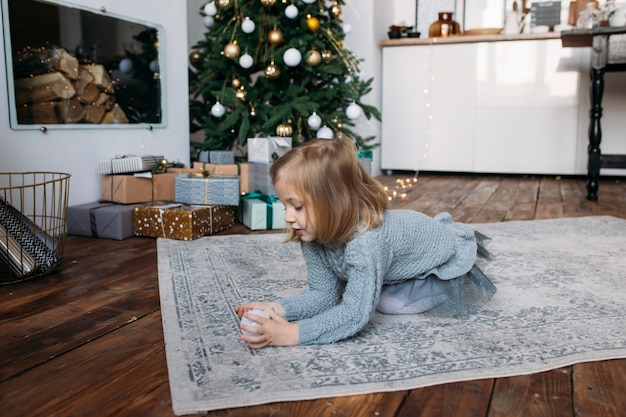 Ragazza a casa che gioca con l'ornamento di natale