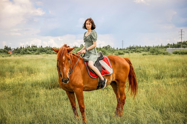 Ragazza a cavallo nel soleggiato campo rurale