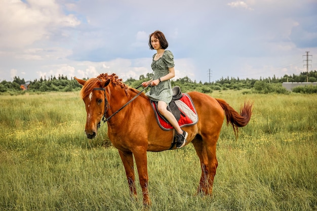 Ragazza a cavallo nel soleggiato campo rurale