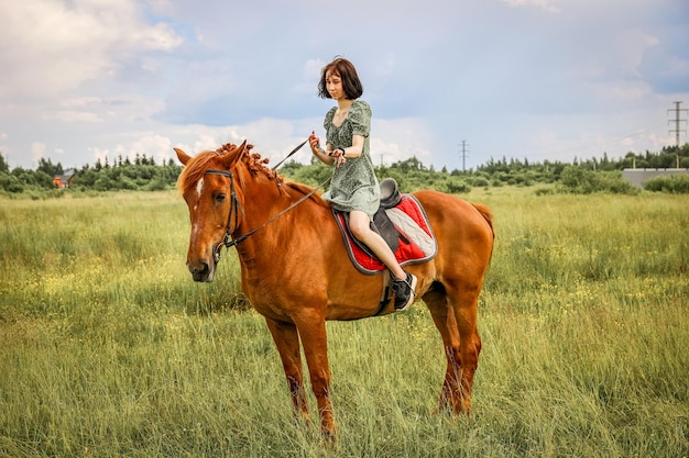 Ragazza a cavallo nel soleggiato campo rurale