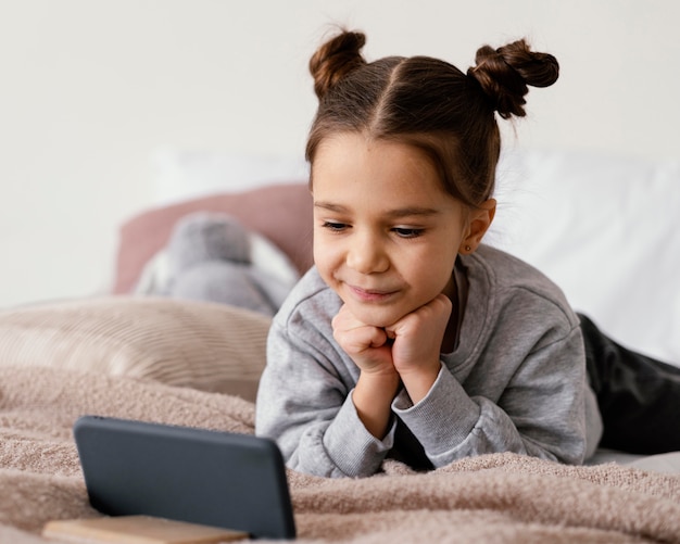 Ragazza a letto a guardare video sul telefono