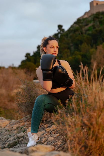 Ragazza adatta con i guantoni da boxe all'aperto