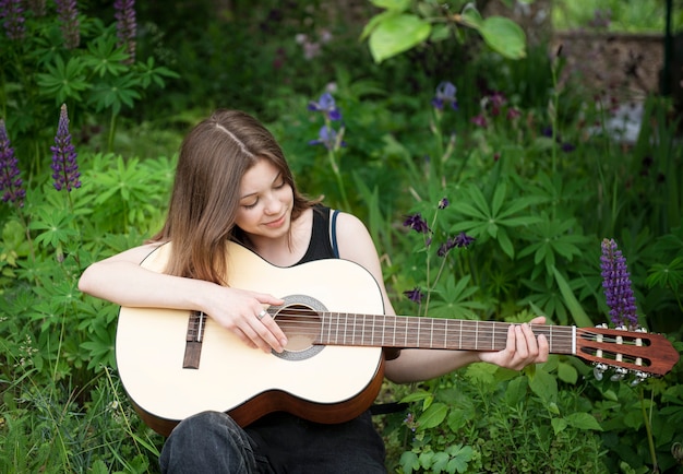 Ragazza adolescente a suonare la chitarra nel parco