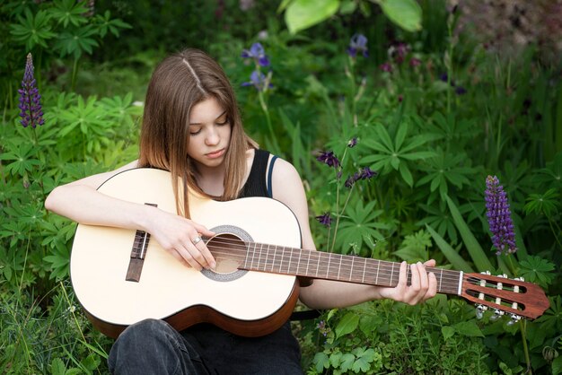 Ragazza adolescente a suonare la chitarra nel parco