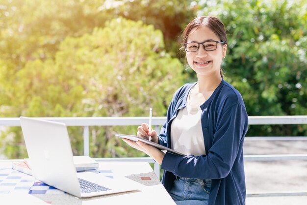 Ragazza adolescente asiatica con computer portatile per l'apprendimento dell'istruzione online o studente programmatore all'università