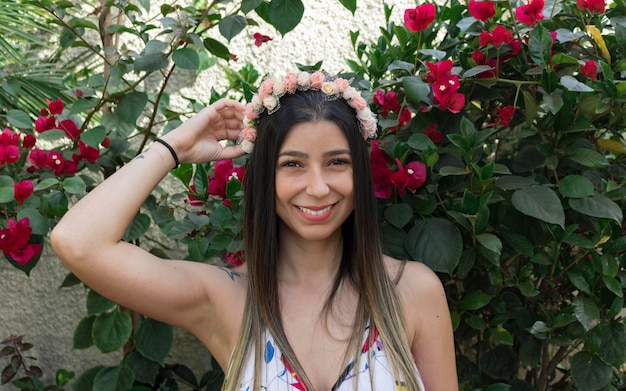 Ragazza adolescente carina bruna con diadema fiorito o cerchietto per capelli sul giardino. Concetto di costume hippie.