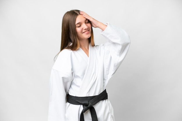 Ragazza adolescente che fa karate su sfondo bianco isolato sorridendo molto
