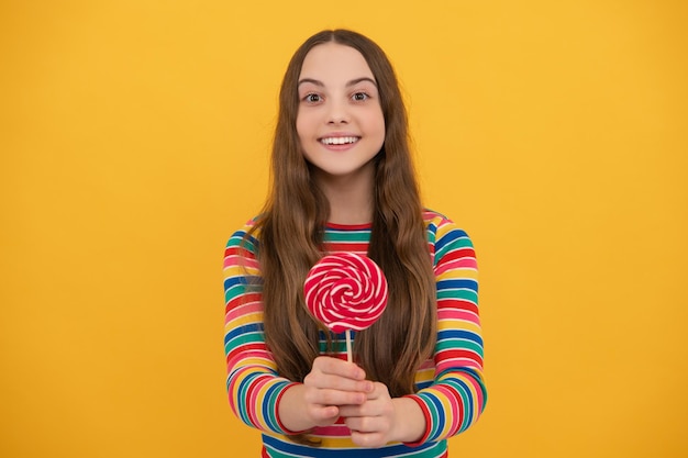 Ragazza adolescente con candy lollipop bambino felice 12 13 14 anni mangiare grande zucchero lollipop dolci candy