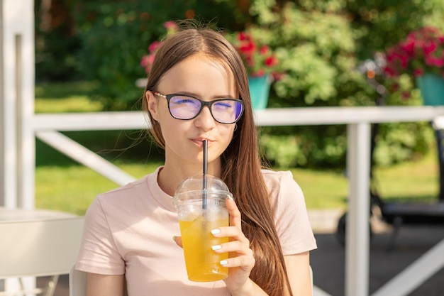 Ragazza adolescente festa in spiaggia con limonata rinfrescante in mano caffè sul mare