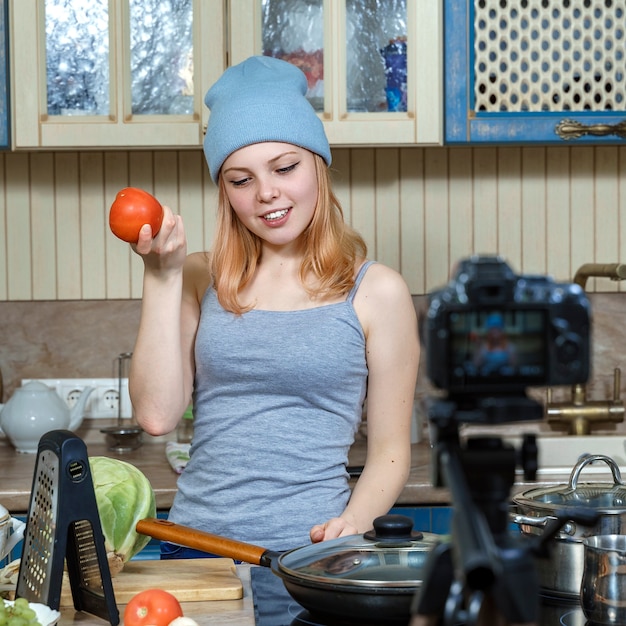 Ragazza adolescente giovane food blogger prepara il cibo, scrive la ricetta alla fotocamera.