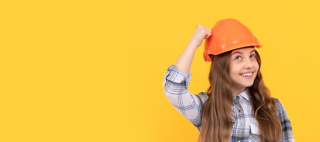 Ragazza adolescente ingegnere Ragazza adolescente divertente con casco e camicia a scacchi build Bambino con cappello rigido design poster orizzontale Spazio per la copia dell'intestazione banner