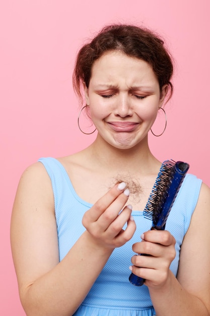 Ragazza adolescente pettine disgusto capelli perdita di capelli colore rosa sfondo inalterato