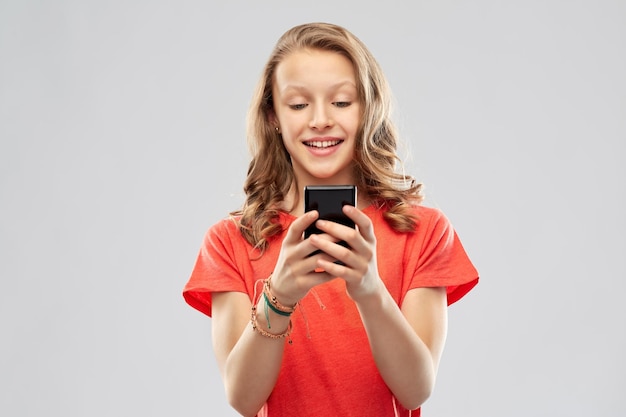 ragazza adolescente sorridente che usa lo smartphone