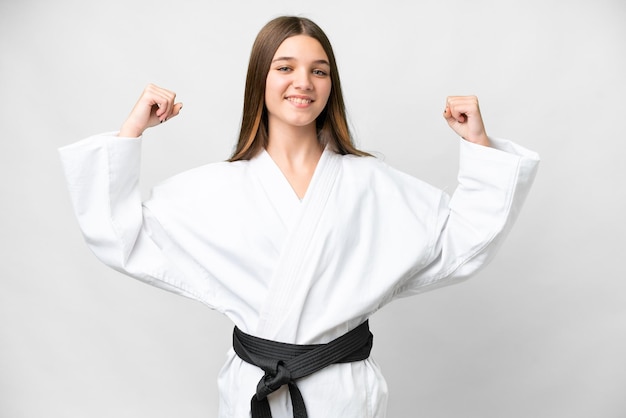 Ragazza adolescente su sfondo bianco isolato facendo karate e facendo un gesto forte