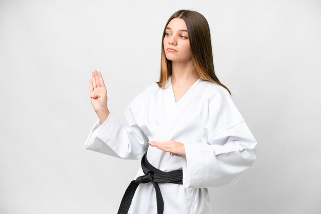 Ragazza adolescente su sfondo bianco isolato facendo karate