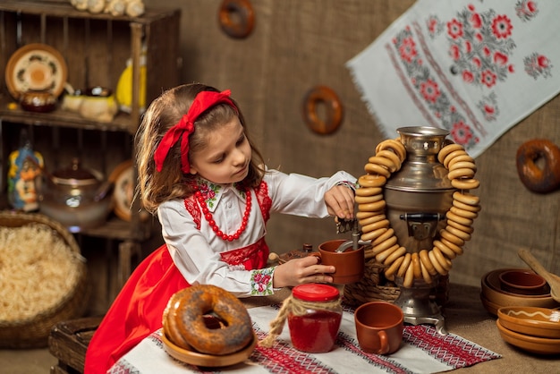 Ragazza adorabile che versa il tè dal samovar