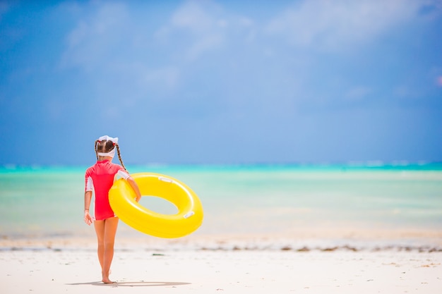 Ragazza adorabile con il cerchio di gomma gonfiabile che va nuotare nel mare