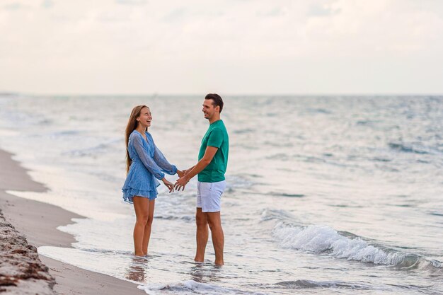 Ragazza adorabile e padre felice che si divertono durante le vacanze in spiaggia