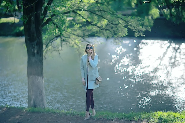 ragazza adulta del parco dello stagno della riva / passeggiata nel parco cittadino, bella ragazza vicino allo stagno nell'area ricreativa urbana all'aperto