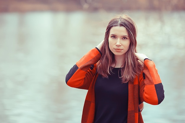 ragazza adulta primaverile all'aperto / marzo in Scozia, una ragazza in un plaid posa nel parco