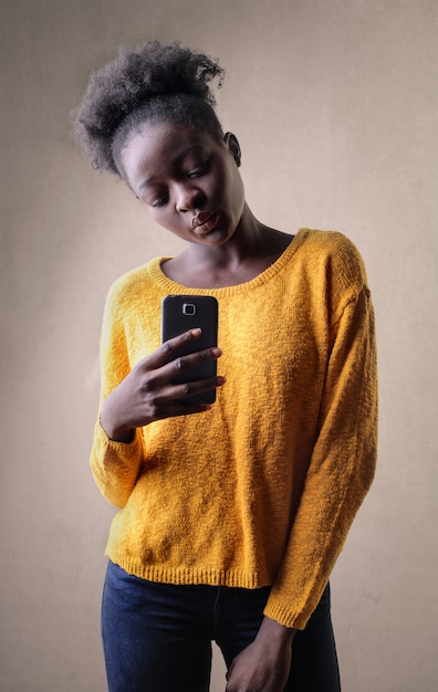 Ragazza afro prendendo una foto con il suo smartphone