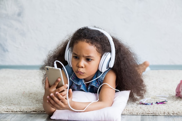 Ragazza afro sveglia a casa che ascolta la musica