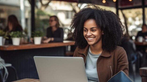 Ragazza afroamericana al ristorante con il computer portatile