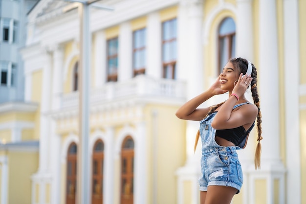 Ragazza afroamericana che ascolta la musica con le cuffie e che sorride