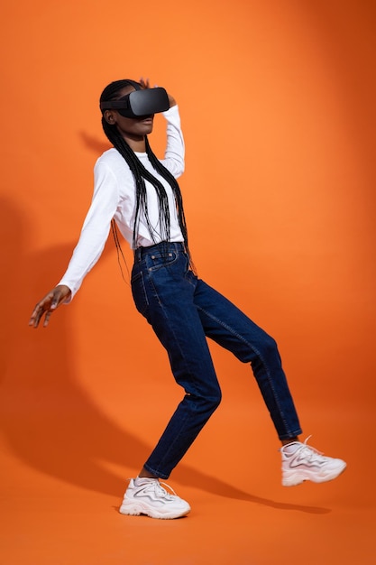 Ragazza afroamericana che cade con gli occhiali vr tenendo le braccia lungo i fianchi