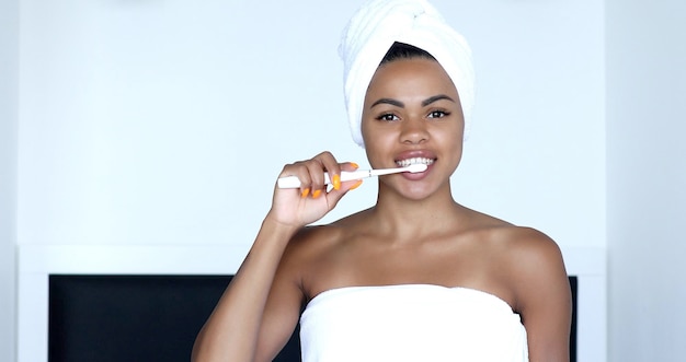 Ragazza afroamericana che lava i denti con lo spazzolino da denti.