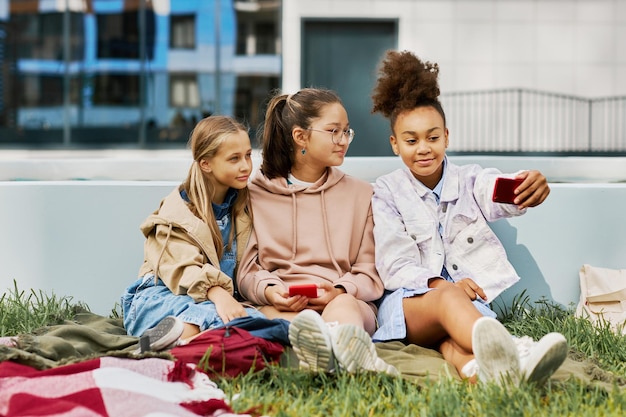 Ragazza afroamericana giovanile che prende selfie con i suoi amici