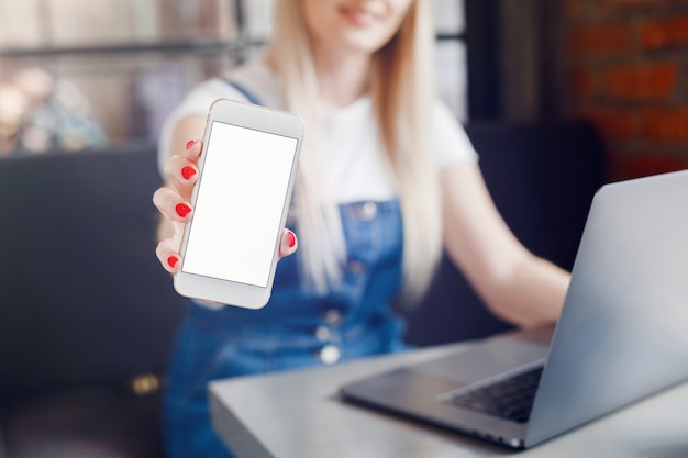 Ragazza al caffè che beve caffè e utilizzando il telefono cellulare. Acquisti online