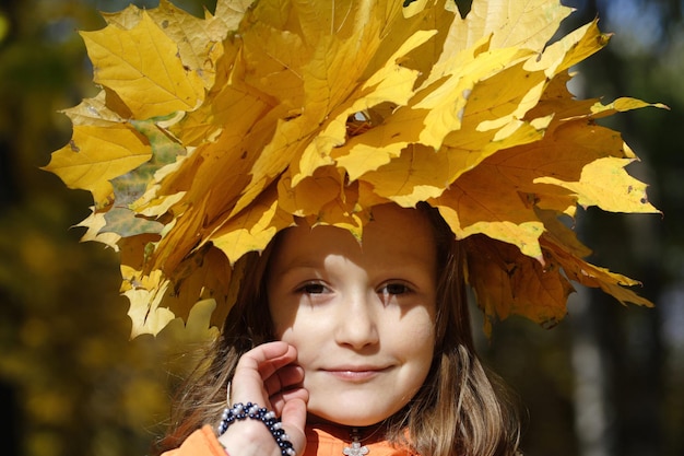 Ragazza al parco con diadema di foglie d'acero gialle