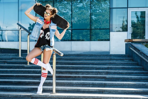 Ragazza alla moda con uno skateboard