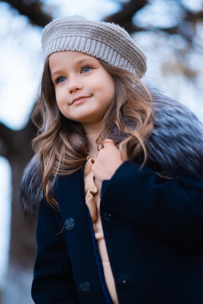 Ragazza alla moda ed elegante in un cappotto blu