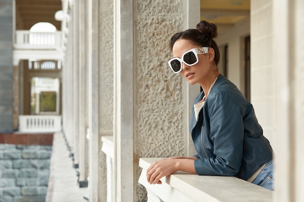 Ragazza alla moda in occhiali da sole, stile di vita, posa alla macchina fotografica.