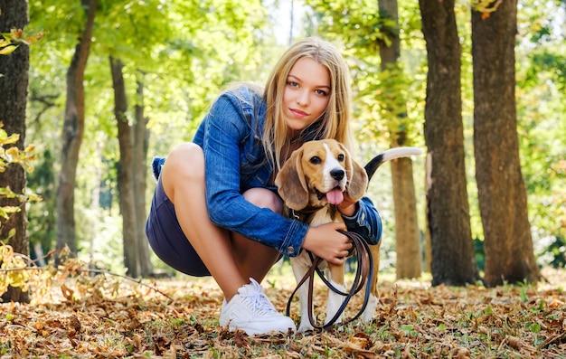 Ragazza allegra che abbraccia un cane al sole del mattino