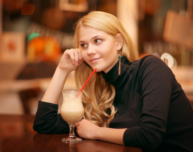 ragazza allegra che beve caffè in un bar di notte