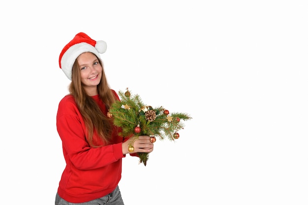 Ragazza allegra con cappello da Babbo Natale che indossa un pullover rosso con rami di albero di natale