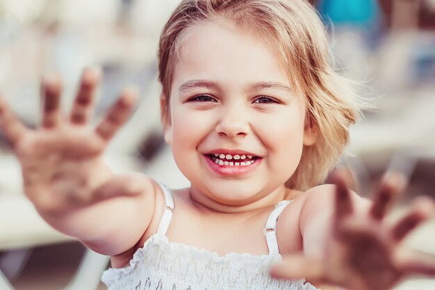 Ragazza allegra di bellezza femminile casuale casuale di stile di vita del ritratto della bella bambina adorabile sul gioco della spiaggia del mare. Concetto di infanzia