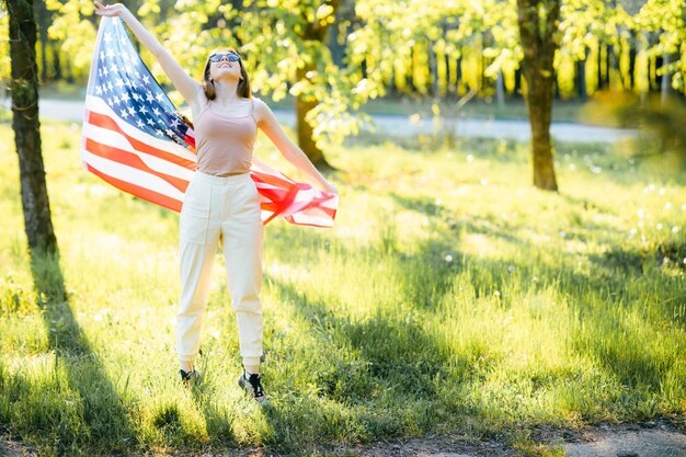 Ragazza americana Felice giovane donna con bandiera USA