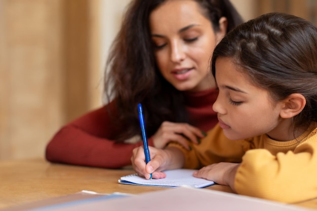 Ragazza araba che fa lezione con il tutor che scrive i compiti in casa