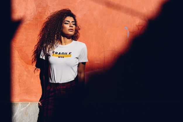 Ragazza araba in abiti casual in strada verso il sole. Concetto di potere della ragazza.