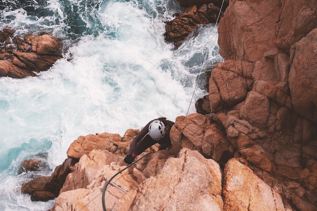 Ragazza arrampicata su una via ferrata, Sant Feliu de Guixols, Catalunya, Spagna