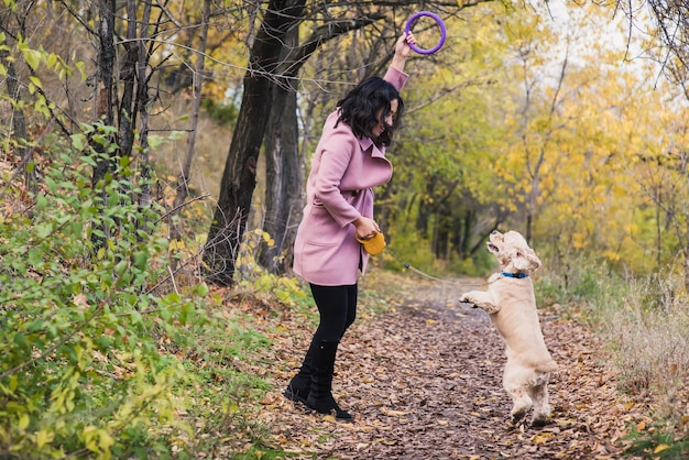 Ragazza asiatica che gioca con il suo cane nel parco.