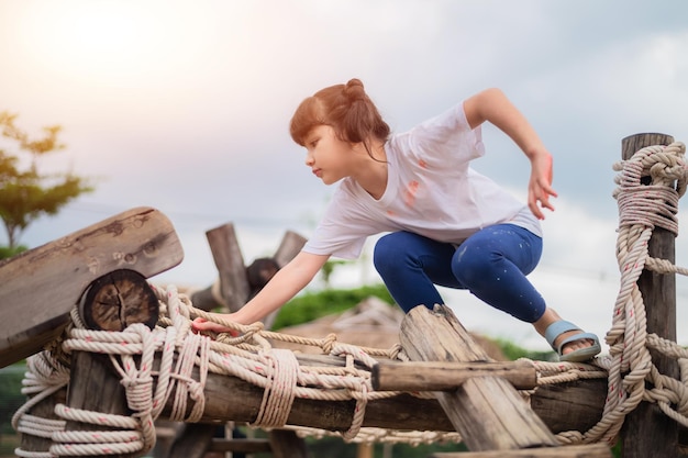 Ragazza asiatica che gioca nel parco giochi felice bambina asiatica divertendosi a giocare nel parco giochi