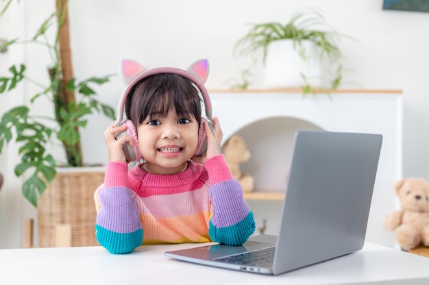 Ragazza asiatica che utilizza il computer portatile per studiare online l'istruzione a casa durante la quarantena domestica. homeschooling, studio online, quarantena domestica, apprendimento online, virus corona o concetto di tecnologia educativa