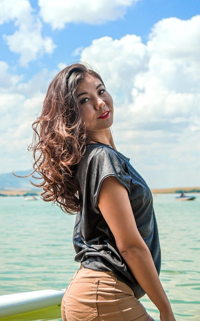 Ragazza asiatica con i capelli lunghi che posa contro il cielo