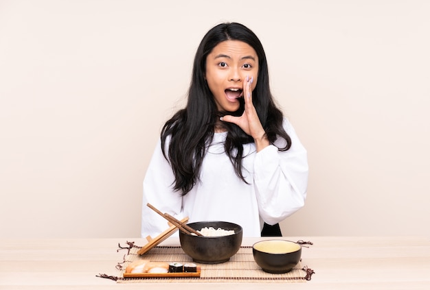 Ragazza asiatica dell'adolescente che mangia alimento asiatico isolato