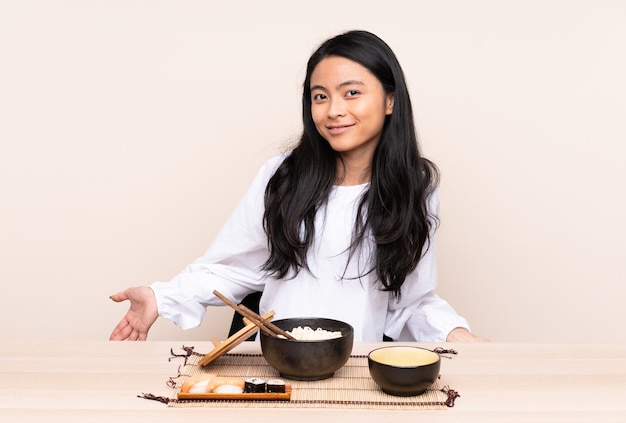 Ragazza asiatica dell'adolescente che mangia alimento asiatico isolato